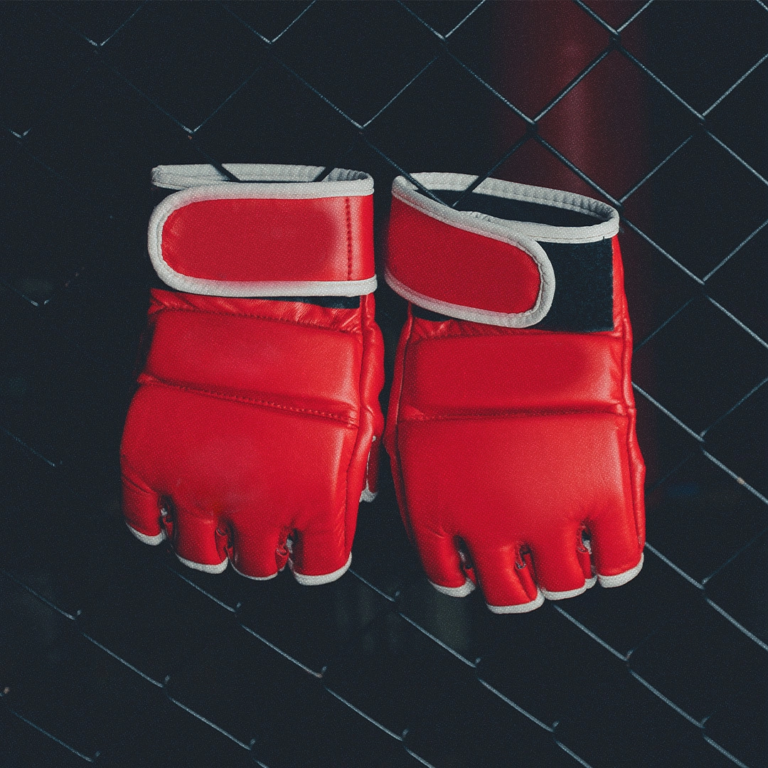 Gants de combattants de MMA accrochés à une grille.