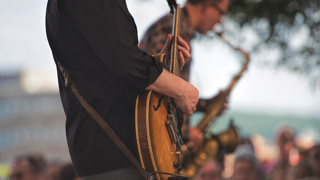 Musicien jouant de la guitare électrique en extérieur.